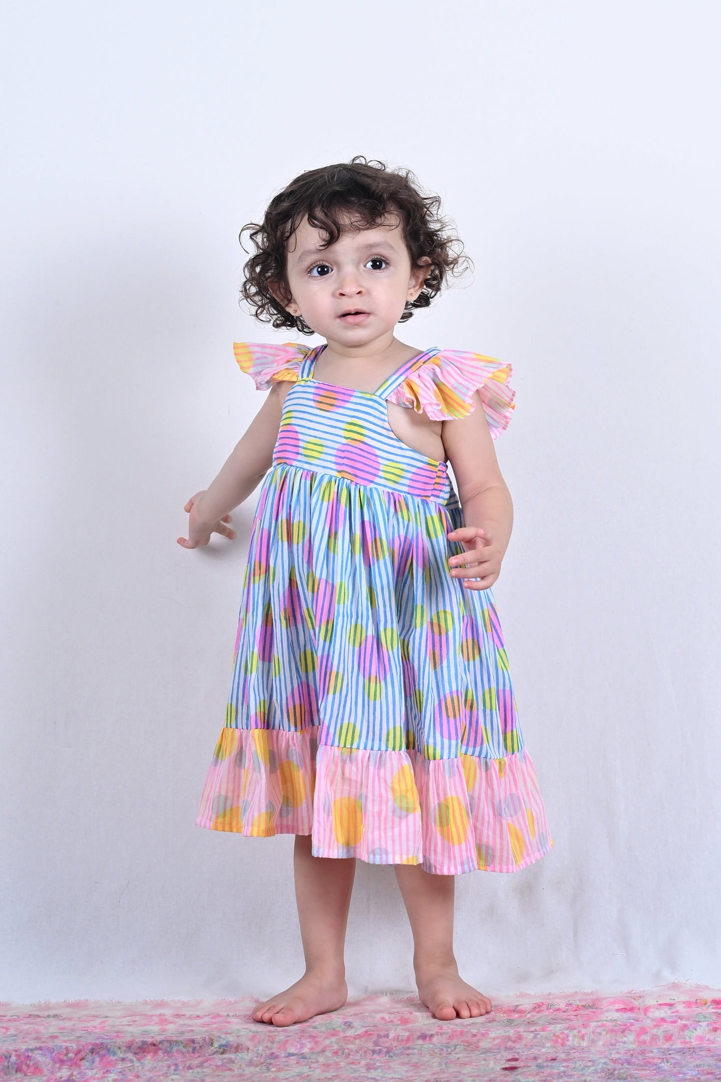 Child wearing a colorful dress on a white background