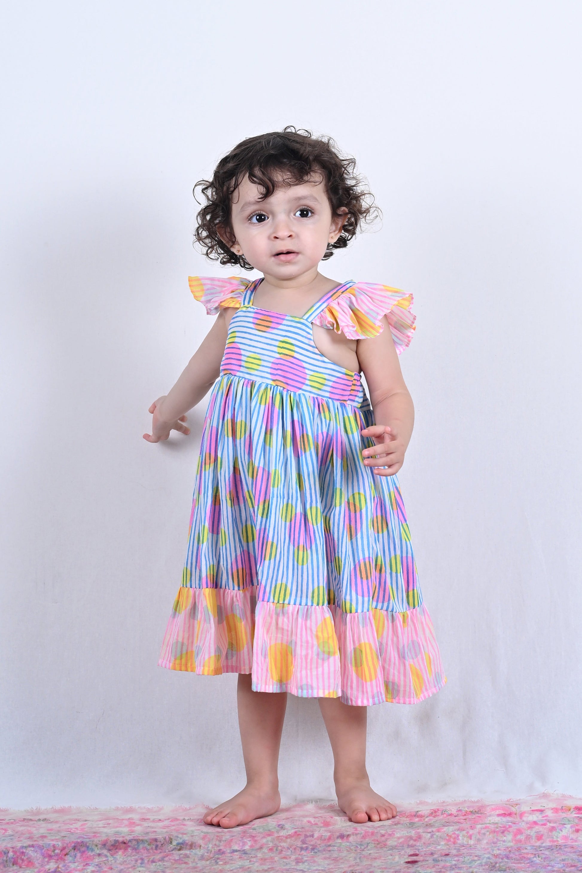 Child wearing a colorful dress on a white background